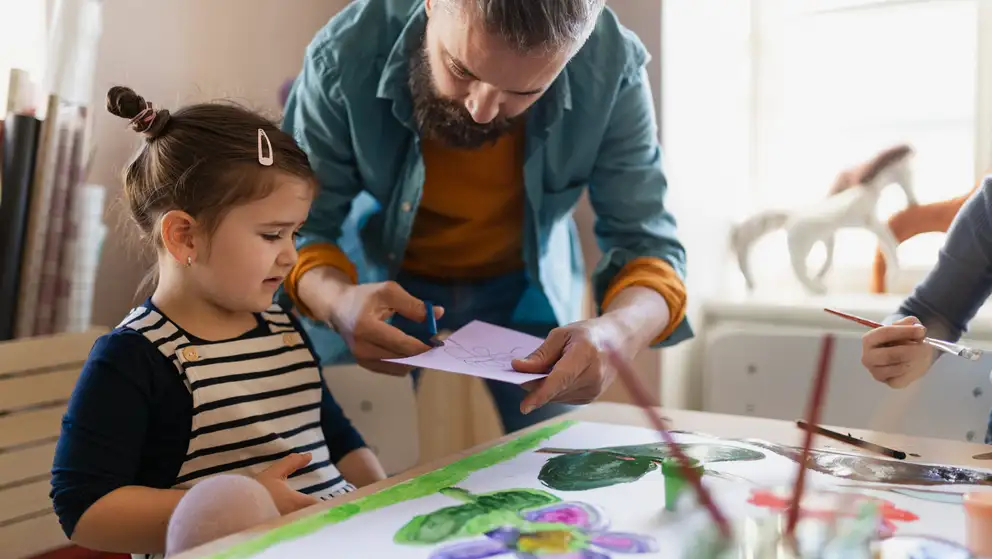 Pædagog laver aktivitet sammen med barn i dagtilbud