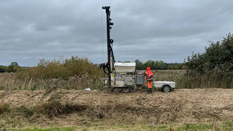 Maskine på larvefødder, der borer i et dige