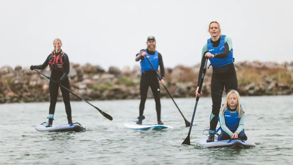 Børn og voksne på paddleboard i Klintholm Havn