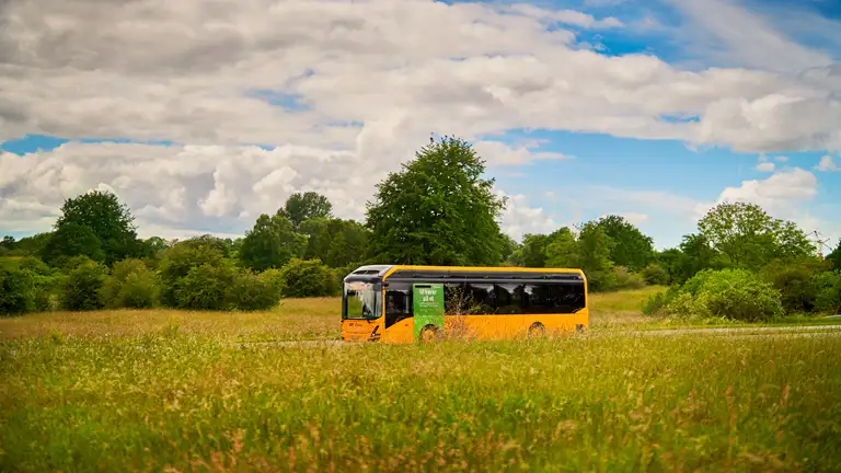 Billede af en Movia Bus der kører igennem landskabet