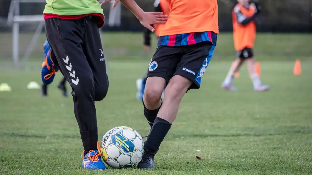 Drenge i løb, der spiller fodbold