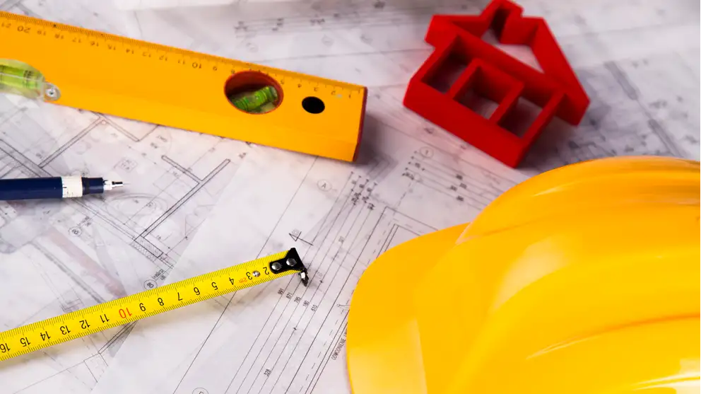 Billede af tegninger og værktøj der illustrerer byggeri